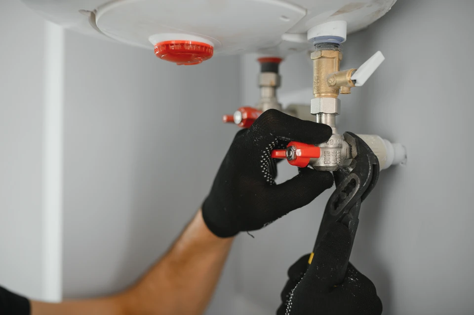 Technicien en climatisation travaillant sur une unité extérieure de pompe à chaleur résidentielle