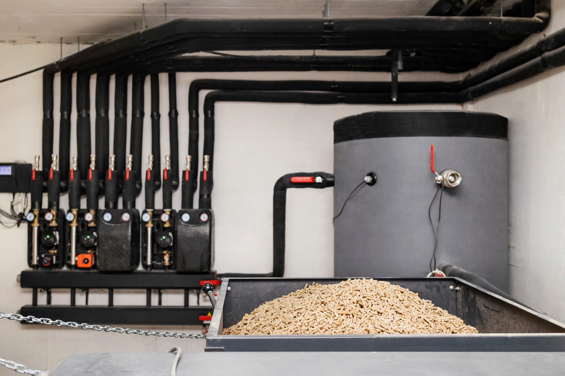 Intérieur d'une chaufferie domestique avec chaudière à granulés de bois rouge en fonctionnement
